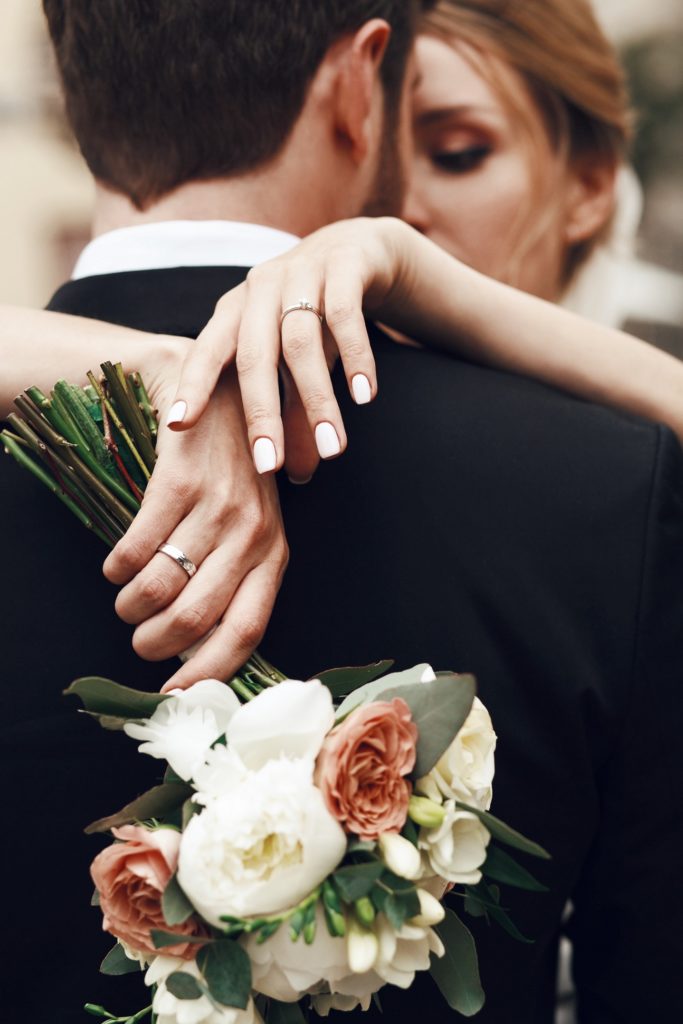 Bride Crosses Her Tender Hands On Groom's Back | Avail Aesthetics in Wake Forest, Raleigh, & Cary, NC